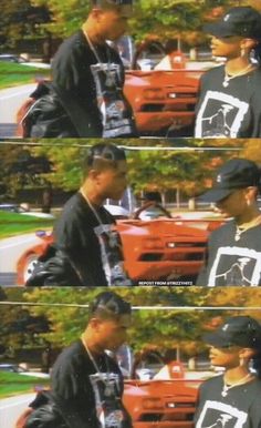 two men are talking to each other in front of an orange truck