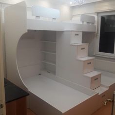 a white loft bed with stairs and drawers