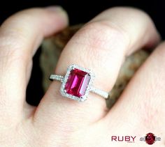 a close up of a person's hand wearing a ring with a pink tourmaline stone