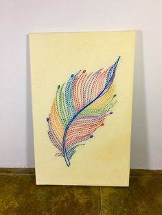 a painting on a wall with a colorful feather painted on it