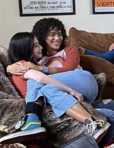 two women sitting on a couch hugging each other