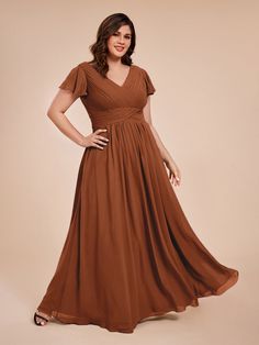 a woman in a brown dress posing for the camera with her hands on her hips