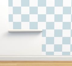 a white and blue checkered wallpaper with a roll of toilet paper on it