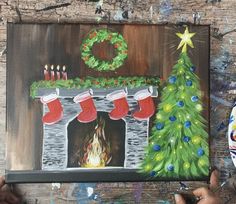 a painting of a fireplace with stockings on it and a christmas tree in the background