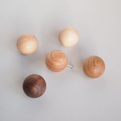 three wooden knobs and two wood balls on a white surface