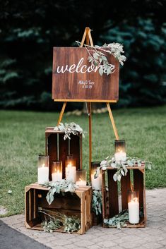 a wooden sign with candles on it that says welcome