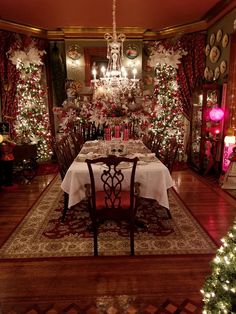 a dining room decorated for christmas with trees and lights