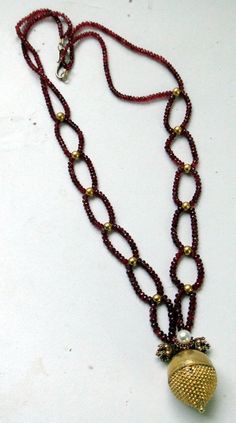 "An exclusive beautiful tribal pendant necklace from Rajasthan northern India. We sourced this piece of gem from a well known tribal family on the outskirts of Jodhpur. Solid well made 22 karat Gold sphere , the bottom half has tiny granulation ending with a tiny ball, the top half is quite shiny finish, set with a natural high grade Burmies Ruby and Pearl ,strung with Micro faceted spinal Ruby and gold beads. Ending with a beautiful golds clasp. Total length-54 cm(21\")we can adjust length, siz Elegant Gemstone Beads In Gold, Traditional Ruby Pendant Necklace, Traditional Hand-strung Round Jewelry, Traditional Ruby Necklaces With Round Beads, Temple Jewelry With Polished Round Beads, Traditional Ruby Beaded Necklace, Traditional Hand-strung Jewelry, Traditional Ruby Necklace With Round Beads, Festive Ruby Gemstone Beads Jewelry