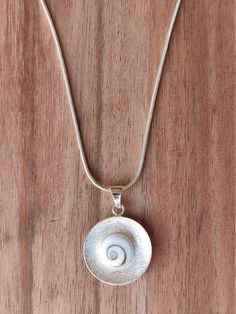 "Handmade 925 Sterling silver shell necklace with a carefully polished Shiva Eye Shell. The shiva shell is into a sterling silver round with scratch finish. This a natural seashell also called \"Ojo de Santa Lucia\". This shell is the a perfect present for all those women who loves the sea and natural beauty. It is great for boho summer brides, wedding guest dresses and also special ocasions. Details: - Including a silver chain. Available in different lenghts: 16, 18, 20 inches (40, 45, 50 cm). Shiva Pendant, Chistmas Gift, Shiva Eye, Summer Bride, Santa Lucia, Eye Pendant, Shell Necklace, Shell Jewelry, Clay Ideas