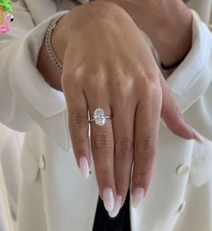 a close up of a person's hand with a diamond ring on their finger