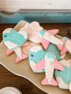 decorated cookies in the shape of airplanes on a plate