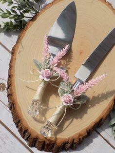 two forks and knifes are sitting on a piece of wood next to some flowers