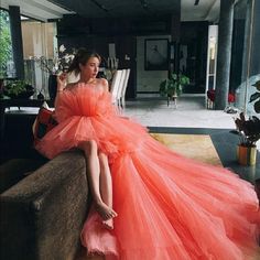 a woman in an orange dress sitting on a couch