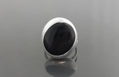 Modern and Chic in Design, this ring is set with Sterling Silver and a genuine black onyx. ► DIMENSIONS: * Ring face size: 2.5 cm diameter ◆ Silver weight : 5.0 gr. ► PRODUCTION METHOD:  💓 Handmade with Love and Care 💓 ► MATERIALS: * Ethically sourced materials * High Quality High Quality Solid 925 Sterling Silver ► All our gemstones are hand selected for best quality assurance, then precisely sawed, and shaped into the desired geometry. The stones are then delicately grinned, sanded and hand Modern Black Round Rings, Modern Black Jewelry With Polished Finish, Modern Oval Black Enamel Rings, Black Modernist Jewelry For Anniversary, Modern Black Round Jewelry, Modern Black Cabochon Rings, Modern Black Oval Jewelry, Black Stone Ring, Onyx Gemstone