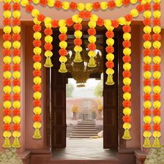 an entrance decorated with yellow and orange paper pom poms, chandeliers and flowers