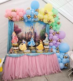 the table is set up with balloons and princesses