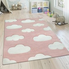 a child's bedroom with pink and white rugs on the floor, baby crib in the background