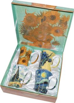 an open box with three coffee mugs and two sunflowers on the inside