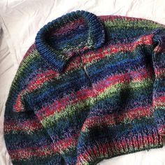 a colorful sweater laying on top of a bed