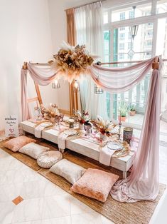 a table set up for an event with pink and gold decorations on top of it