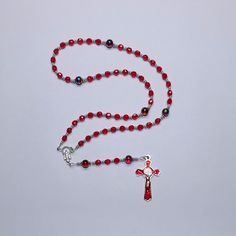 Handmade Catholic Rosary -Small, light Siam (red) glass beads, swirled red beads with blue and yellowish gold swirls.AVE (Hail Mary Beads): 6 mm, Czech light Siam red fire polished glass beadsPATER (Our Father Beads): 8 mm, red swirl glass beadsCROSS: Approx. 2", red enamel inlay, silver tone metal St. Benedict crucifixCENTERPIECE: Miraculous Mary LENGTH: 17 inches Also known as Dominican Rosary and Holy Rosary. The St. Benedict medal serves as protection against evil and temptation, secures a t Red Czech Glass Spiritual Jewelry, Adjustable Red Faceted Beads, Spiritual Red Jewelry For Christmas, Adjustable Red Rosary With 8mm Beads, Red Spiritual Jewelry With Spacer Beads, Adjustable Red Czech Glass Beads, Handmade Red Beads For Christmas, Handmade Red Christmas Beads, Red Czech Glass Jewelry With Spacer Beads