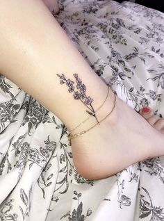 a woman's foot with a flower tattoo on the left side of her leg