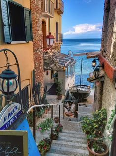 an alley way with stairs leading up to the water