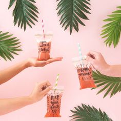 three people holding drinks in their hands with palm leaves around them on a pink background