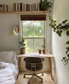 a bedroom with a bed, desk and bookshelf next to a large window