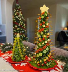 two christmas trees made out of fruits and veggies are sitting on a table