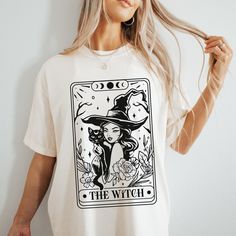 You will love this short sleeve, crew neck, Comfort Colors witchy vibes black cat lover Tee. This T-shirt will make a great gift for all black cat moms, green witches + tarot magick lovers. <3 ABOUT * ADULT MEDIUM WEIGHT SHORT SLEEVE T-SHIRT / Comfort Colors 1717 Brand * Fabric: 100% cotton / Medium weight fabric (6.1 oz/yd² (206.8 g/m * Made with DTF (Direct to Garment Printing process) * Cozy + Relaxed fit / Double-needle stitching throughout / No side seams / Sewn in twill inner neck label / Witchy Short Sleeve Cotton Tops, Witchy Cotton Short Sleeve Tops, Witch Tarot Card, Witchy Graphic Print Crew Neck Tops, Witches Tarot Cards, Witchy Short Sleeve T-shirt With Graphic Print, Witchy Short Sleeve Cotton T-shirt, Cotton Witchy Short Sleeve T-shirt, Cotton Short Sleeve Witchy T-shirt