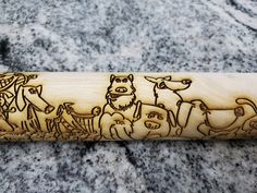 a wooden stick with an image of animals on it sitting on top of a granite surface