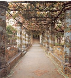 the walkway is lined with colorfully painted tiles and trees on either side of it