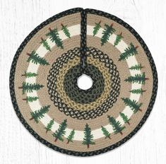 a round rug hanging on the side of a white wooden wall with pine trees in it