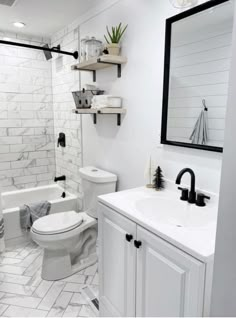 a white bathroom with black and white accessories