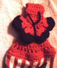 a crocheted teddy bear sitting on top of a red and white striped chair