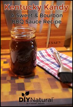 a jar filled with bbq sauce sitting on top of a wooden table next to a spatula