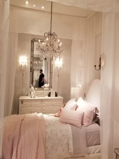 a bedroom with a chandelier hanging from the ceiling and a bed in front of it