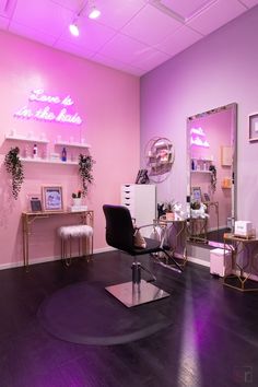 a salon with purple lighting and mirrors on the wall, chairs in front of it