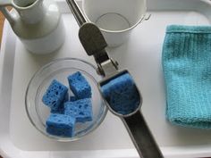 a white tray topped with blue crochet squares next to a cup and saucer