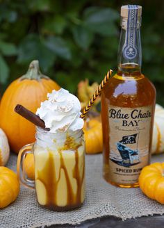 a glass jar filled with liquid next to pumpkins