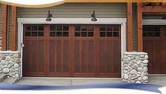 an image of a garage with two doors and stone pillars on the side of it