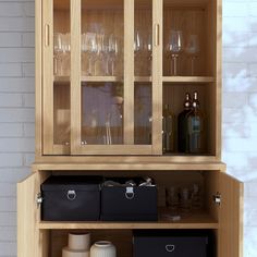 a wooden cabinet with wine glasses and bottles on it's shelves next to a brick wall