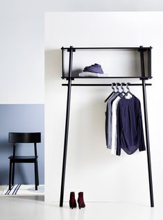 a clothes rack with shoes and shirts hanging on it