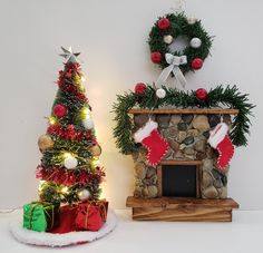 a christmas tree next to a fireplace with stockings on it