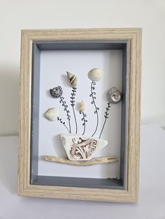 a shadow box with seashells and flowers in it