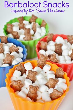 three colorful bowls filled with marshmallows and chocolate dog treats on top of each other