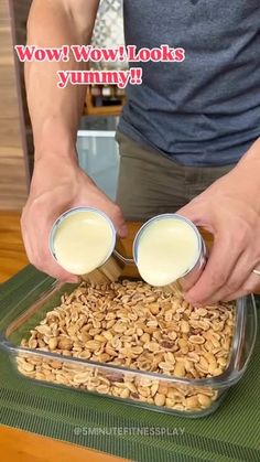 a person pouring milk into a container filled with nuts and oats on top of a table