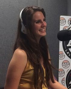 a woman wearing headphones sitting in front of a microphone