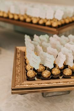 a table topped with lots of chocolates and candies on top of a wooden tray